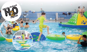 Boy in pool on inflatable obstacle course