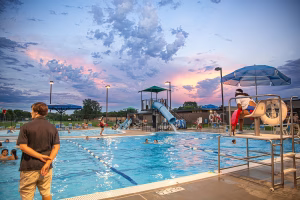 Outdoor pool with slide and sunset